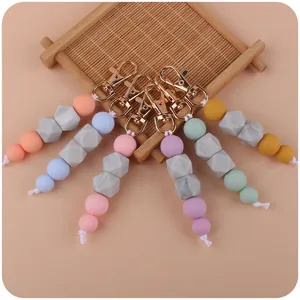 Detail of marble silicone bead keychains in macabre colors on bamboo background