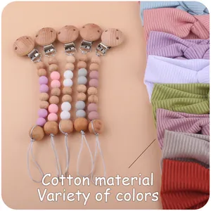 Detailed view of handmade silicone and wooden pacifier clips with cotton baby headbands