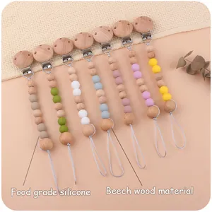 Detail of pacifier clips made of food grade silicone and beech wood in Morandi colors