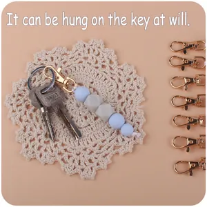Handmade keychain with blue silicone beads and gold lobster clasp on lace coaster