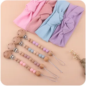 Detail of four ribbed knit baby headbands with matching silicone and wood pacifier clips