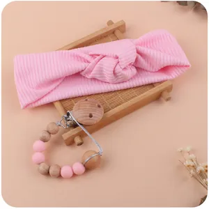Detailed view of pink baby headband and silicone bead pacifier clip with wooden beads