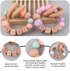 Macro detail of personalized beech wood baby teether with silicone beads and BABY engraving