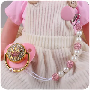 Detail of pink crown pacifier with crystal rhinestones and white pearl clip chain