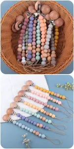 Detalle de sujetachupetes para bebés hechos de madera de haya y cuentas de silicona pastel