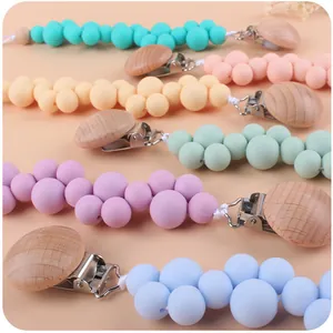 Detalle de los sujetachupetes de silicona en colores pastel con clip de madera y metal