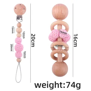 Pink crochet and beech wood baby rattle with matching pacifier clip set on white background