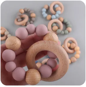 Close-up of a baby teether toy made of natural beech wood rings and soft silicone beads