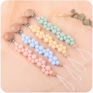 Detalle de sujetachupetes de silicona en colores macaron con clips y cuentas de madera