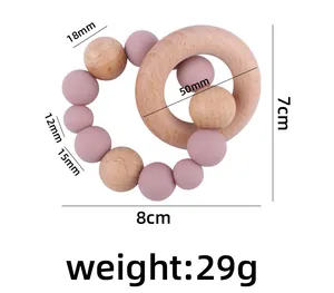 Detailed view of baby teething ring with beech wood circles and dusty pink silicone beads