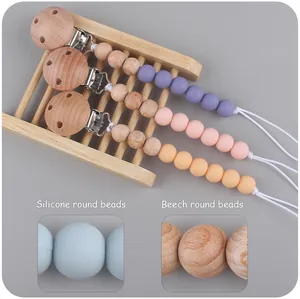Detail of beech wood and silicone beads pacifier clips in pastel macaron colors
