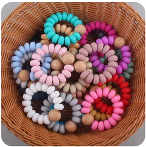 Braccialetti da dentizione in silicone colorato con perline in legno di faggio in un cesto
