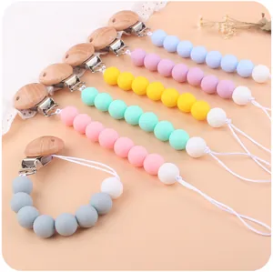 Dettaglio catenelle per ciuccio in silicone color pastello con clip in faggio