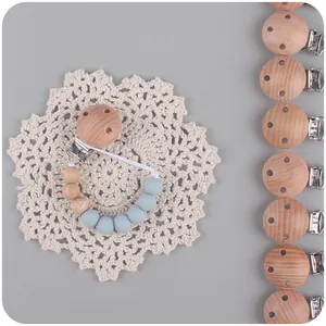 Beech wood pacifier chain with light blue silicone beads on white lace background