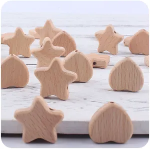 Macro detail of natural beech wood star and heart beads for DIY baby pacifier clips