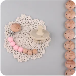 Detail van fopspeenketting met roze siliconen kralen en beukenhouten clip op kant