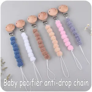 Detail of 6 colorful plush ball baby pacifier clips with natural wooden clips and soft cord