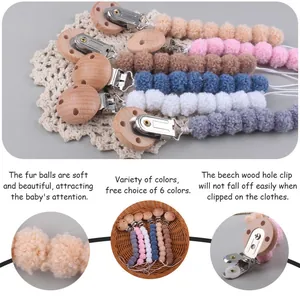 Close-up of soft plush balls and natural beech wood clip for pacifier holder chain