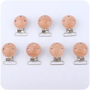 Detalle de siete pinzas para chupete de madera de haya pulida de 30mm con veta de madera natural