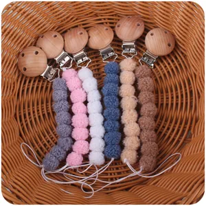 Detail of 6-pack colorful plush ball baby pacifier clips in a wicker basket