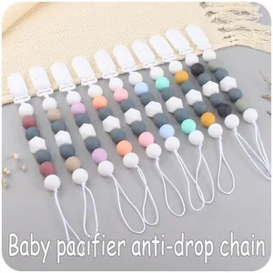 Flat lay of colorful silicone pacifier clips with hexagon beads and plastic clasps