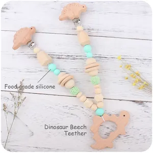 Macro shot of dinosaur beech wood teether with food grade silicone and crochet beads
