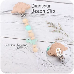 Detail of baby pacifier clip with dinosaur beechwood clip and mint green silicone beads