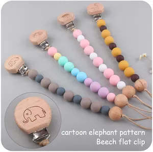 Detalle de clips de madera de haya con grabados de animales y cuentas de silicona