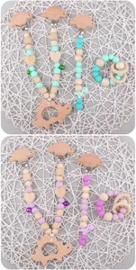 Close-up of baby silicone dinosaur teether set with pacifier clips and colorful bells