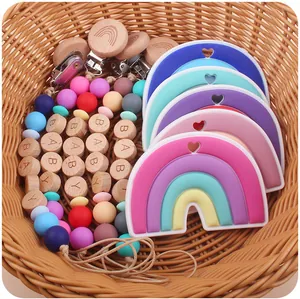 Detail of colorful silicone rainbow teether and wooden bead pacifier clip set in a basket