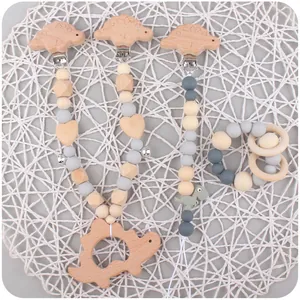 Detail of wooden dinosaur baby teether set with silicone beads and small bells