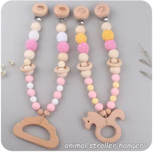 Détail de quatre attaches pour poussette en bois de hêtre et perles de silicone pastel