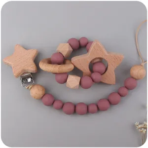 Detail of beech wood baby pacifier clip and silicone teether set in dusty pink