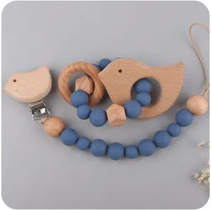 Detail of beech wood bird pacifier clip and blue silicone bead teething ring set