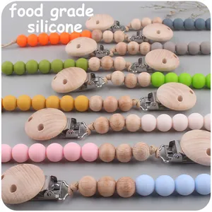 Diverses attaches-tétines colorées en silicone de qualité alimentaire et hêtre en vue de dessus