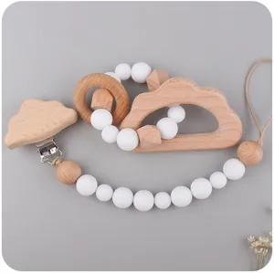 Detail of wooden cloud pacifier clip and silicone teething ring set for babies
