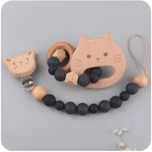 Close-up of beech wood baby pacifier clip and cat teething ring set with silicone beads
