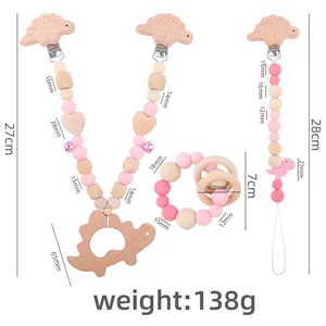 Pink silicone dinosaur teething toy set with wooden clips and pacifier chain accessories