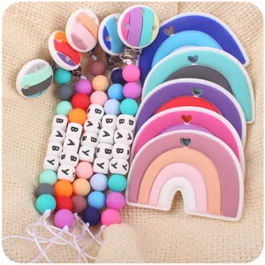 Detail of colorful silicone rainbow teething clips and baby pacifier chains in pastel colors