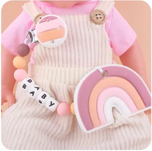Close-up of silicone rainbow teether with pink bead clip and BABY letter beads