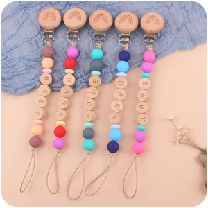 Five assorted beech wood and silicone baby pacifier clips with rainbow and BABY engravings