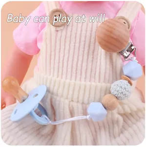 Detail of baby pacifier clip set with blue silicone beads and beech wood clip on doll outfit