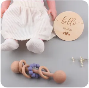 Gros plan du hochet en bois pour bébé avec anneau silicone et carte d'étape Hello World
