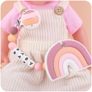 Silicone baby pacifier clip with colorful beads and rainbow teether on a doll model