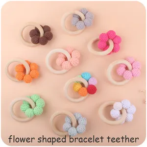 Detail of flower shaped baby teethers with natural wood rings and colorful crochet beads
