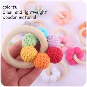 Macro detail of colorful crochet beads and smooth natural beech wood ring for baby teething