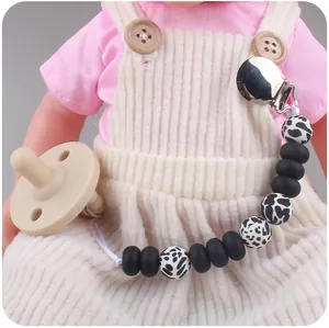 Close-up of leopard print silicone bead pacifier chain with clip on a baby doll