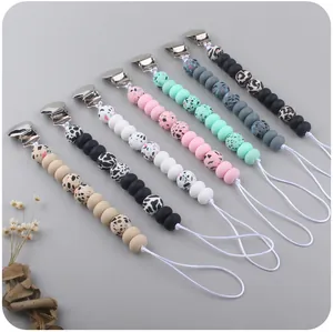 Detail view of seven leopard print and silicone bead pacifier clips in various soft tones