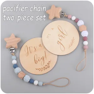 Detail showing silicone pacifier clips with wood beads and baby milestone discs