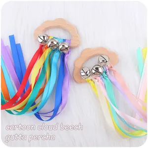Detail of beech wood cloud teether with colorful silk ribbons and silver metal bells